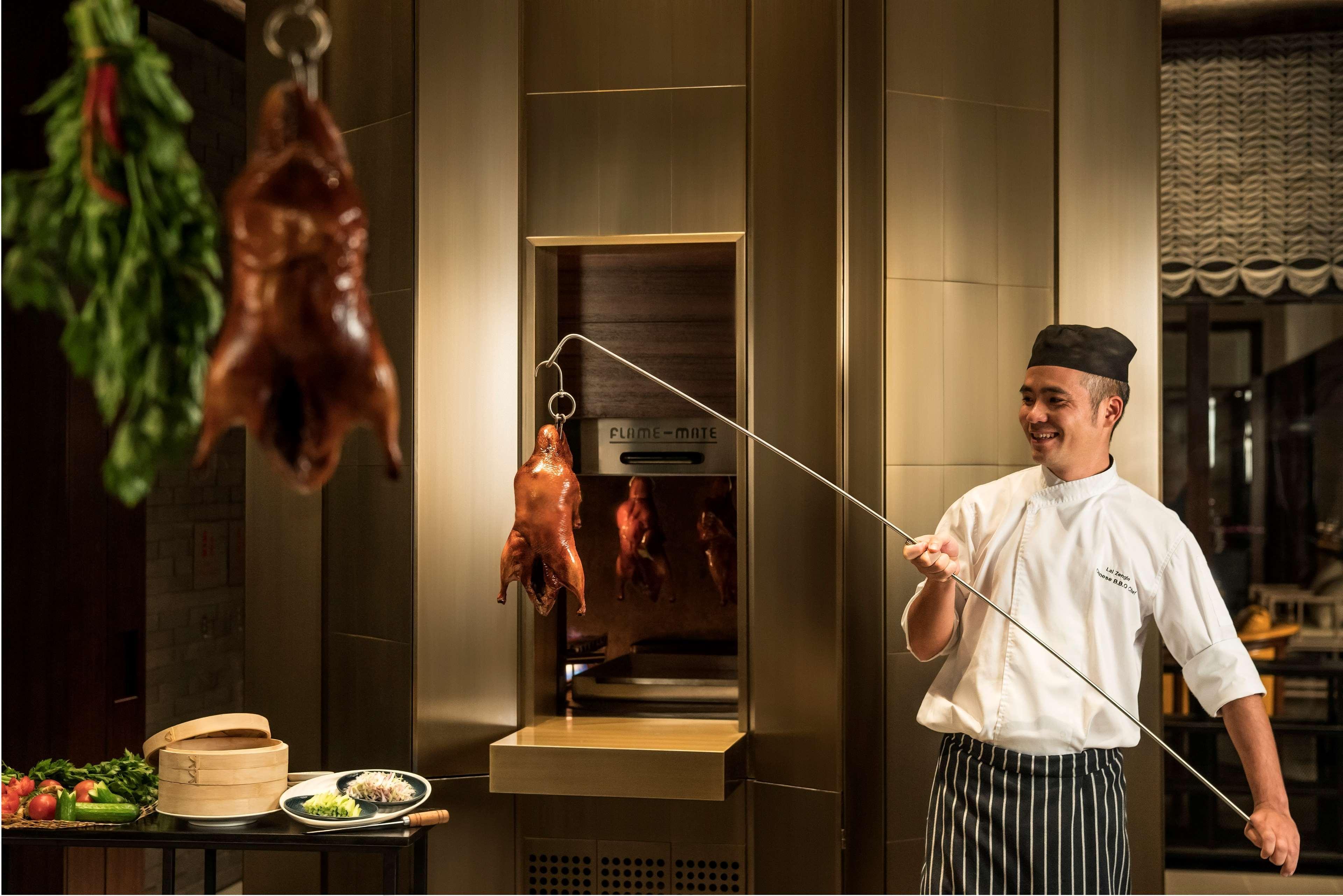 Shangri-La Colombo Exterior photo Chef pulling a duck out of a hanging oven